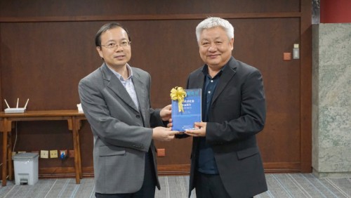 Editor executivo Dr. Lou Sheng Hua, oferece o Livro Azul ao bibliotecário da Universidade de Ciência e Tecnologia de Macau, Dr. Tai Long Kei