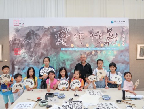 小朋友拿着作品與老師合照